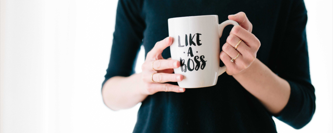 Fotoausschnitt von Händen einer Frau, die eine Tasse mit der Aufschrift "Like A Boss" halten