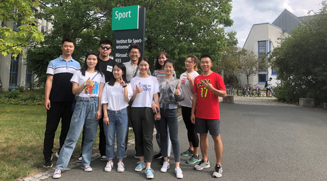 Asiatische Austauschstudenten posieren vor dem Institut für Sportwissenschaften der Universität Bayreuth